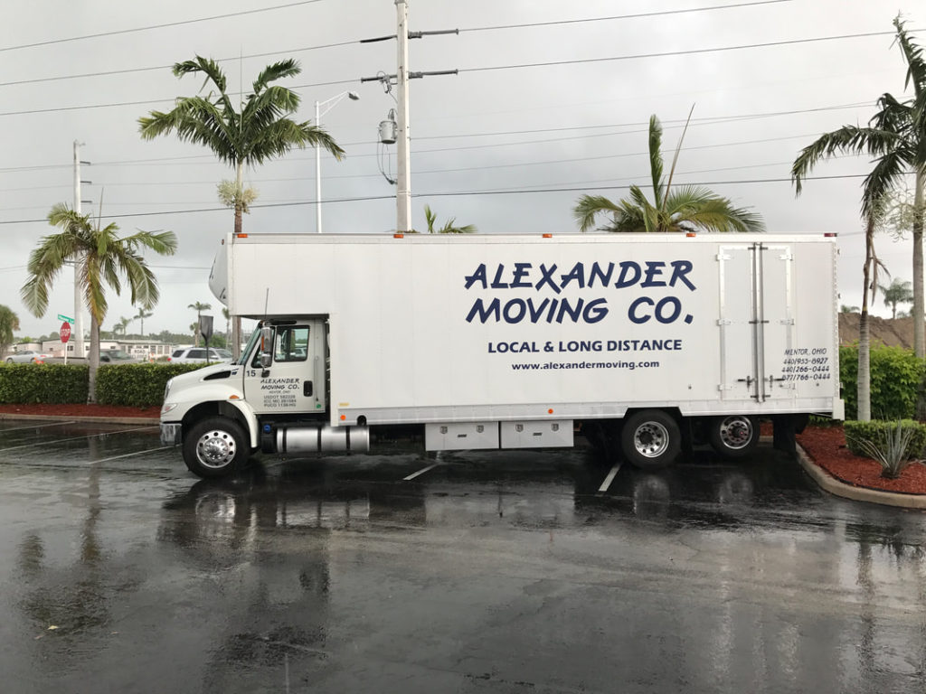 Alexander Moving truck parked in a tropical location for specialized logistics solutions and long-distance transport.